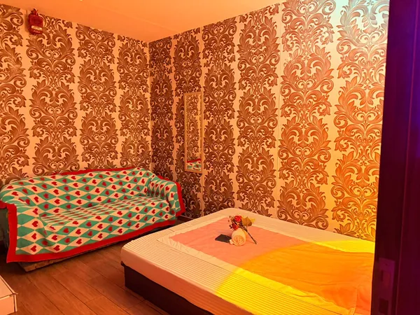 Gold damask treatment room with massage bed and sofa at Opaline Spa Dubai