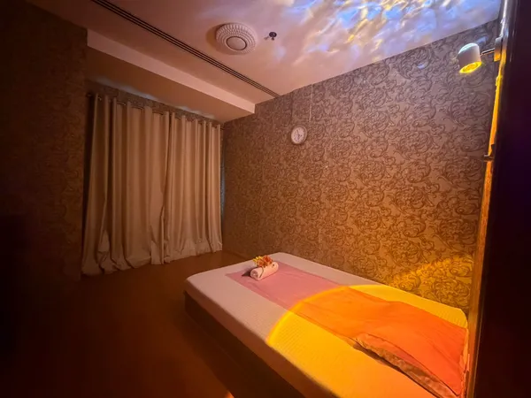 Massage treatment room with heat lamp and soft curtains at Opaline Spa Dubai